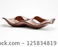 Minimalistic design featuring glossy chocolate wave sculpture for art decor 125834819