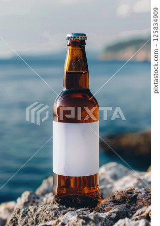 Serene Beachside With Single Beer Bottle on Rocky Shore Serene Beachside With Single Beer Bottle on Rocky Shore 125834909