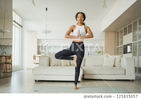 Yoga fitness workout training. Healthy African girl practicing yoga at home. Woman training Pilates doing sports exercise on yoga mat indoor. Girl have training workout for weight loss. Sport fitness Yoga fitness workout training. Healthy African girl practicing yoga at home. Woman training Pilates doing sports exercise on yoga mat indoor. Girl have training workout for weight loss. Sport fitness 125835057
