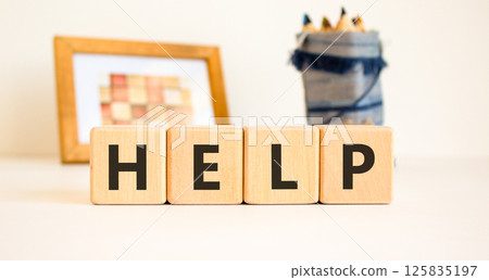 Help symbol. Concept word Help on beautiful wooden blocks. Beautiful picture frame and colored pencils. Beautiful white table white background. Business, lifestyle, support help concept. Copy space. 125835197