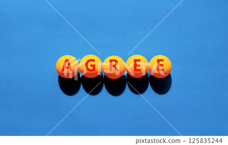 Agree symbol. Concept word Agree on beautiful yellow tennis ping pong balls. Beautiful wooden table wooden background. Business agree concept. Copy space. Agree symbol. Concept word Agree on beautiful yellow tennis ping pong balls. Beautiful wooden table wooden background. Business agree concept. Copy space. 125835244