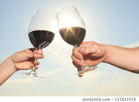 couple drinking a bottle of red wine outside 125835559