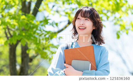 Smiling woman/businesswoman walking outdoors 125836160