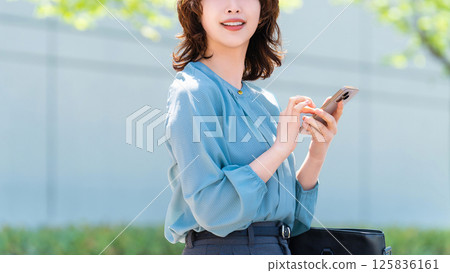 Woman/businesswoman using smartphone outdoors 125836161