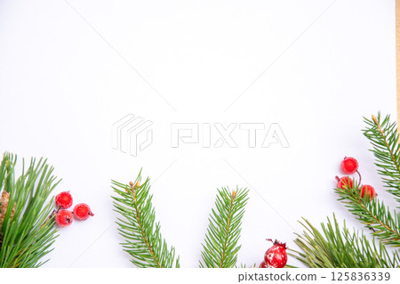 Holiday-themed blank space with pine branches and red berries on a white background for festive decorations and greeting cards 125836339