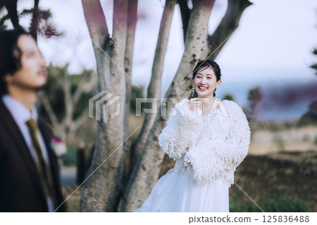 A young couple taking pre-wedding photos at Jogashima 125836488