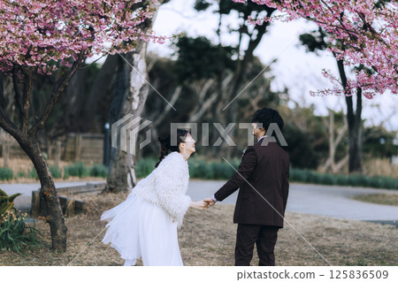 A young couple taking pre-wedding photos at Jogashima 125836509
