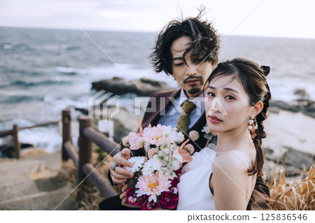A young couple taking pre-wedding photos at Jogashima 125836546