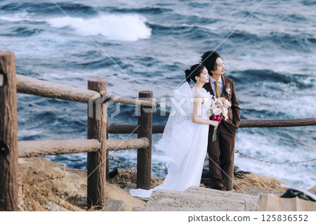 A young couple taking pre-wedding photos at Jogashima 125836552
