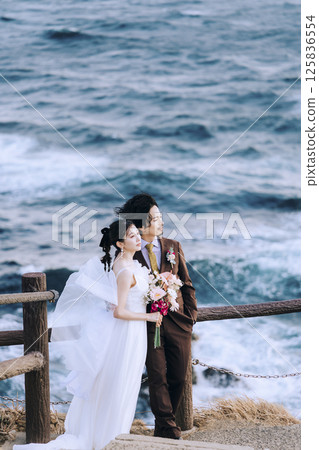 A young couple taking pre-wedding photos at Jogashima 125836554