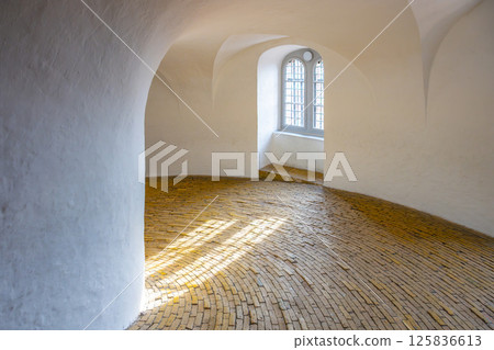 The spiral ramp of the Round Tower invites visitors to ascend through its elegant curves, showcasing a stunning brick floor and soft natural light streaming through arched windows. The spiral ramp of the Round Tower invites visitors to ascend through its elegant curves, showcasing a stunning brick floor and soft natural light streaming through arched windows. 125836613