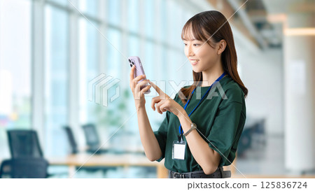 Smiling woman/businesswoman using a smartphone Smiling woman/businesswoman using a smartphone 125836724