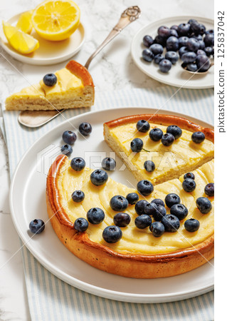 Cheesecake with blueberries sliced on a plate Cheesecake with blueberries sliced on a plate 125837042
