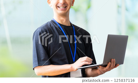 Smiling male businessman with laptop 125837116