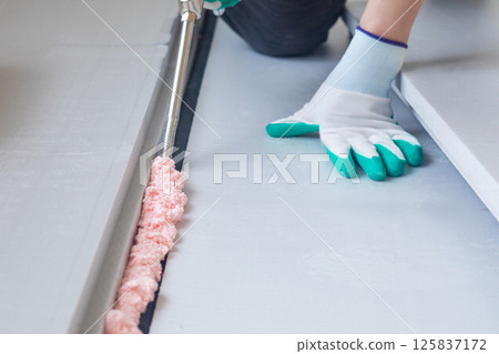 Application of foam adhesive for insulation installation Application of foam adhesive for insulation installation 125837172