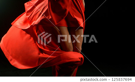 Brunette Woman in Ruby Red Dress Dancing Against a Black Background , Freeze Motion 125837694