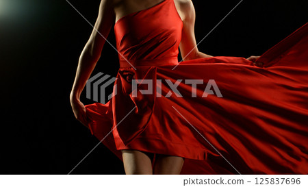 Brunette Woman in Ruby Red Dress Dancing Against a Black Background , Freeze Motion 125837696