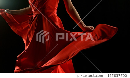 Brunette Woman in Ruby Red Dress Dancing Against a Black Background , Freeze Motion 125837700