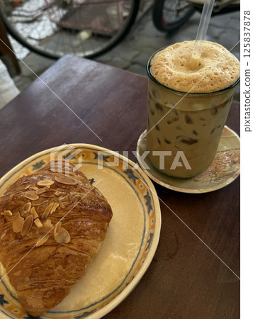 vertical photos croissant with almond flakes and egg coffee in Vietnam 125837878