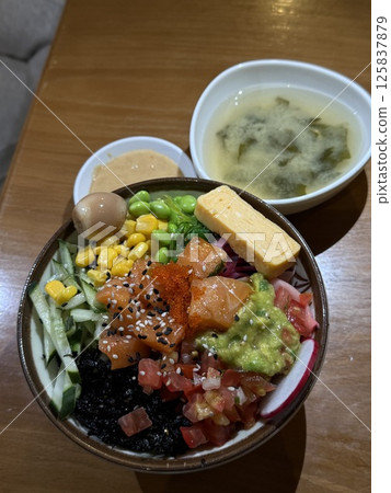 vertical photo Poke bowl soup Wok rice with vegetables. Composition on black background. The Art of Japanese Cuisine. Food photography for menu and sushi bar decoration 125837879