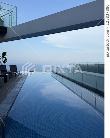 vertical photo Luxury roof top swimming pool with infinity edge, early morning sunrise, colorful sky, exotic location. vertical photo Luxury roof top swimming pool with infinity edge, early morning sunrise, colorful sky, exotic location. 125837880
