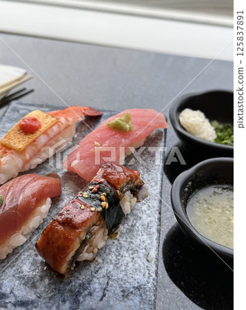 Sushi composition on black background. The Art of Japanese Cuisine. Food photography for menu and sushi bar decoration Sushi composition on black background. The Art of Japanese Cuisine. Food photography for menu and sushi bar decoration 125837891