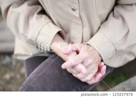 Woman's hands clasped in a gesture of contemplation. Woman's hands clasped in a gesture of contemplation. 125837978