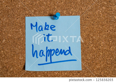 Handwritten make it happen note pinned on cork board promoting action and achievement Handwritten make it happen note pinned on cork board promoting action and achievement 125838203