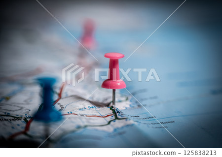 Pink push pin marking location on map with other pins in background Pink push pin marking location on map with other pins in background 125838213