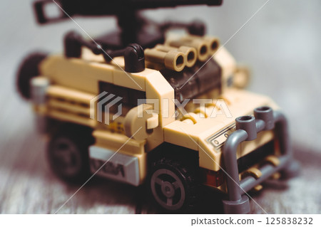 Toy military car equipped with rocket launcher stands ready for action 125838232