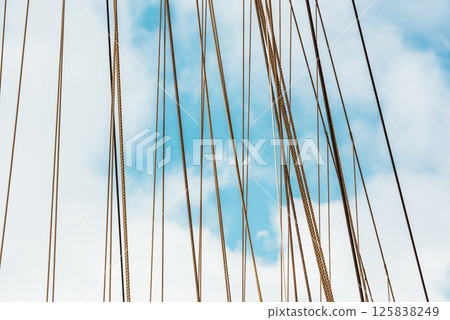 Sailboat ropes against blue sky, abstract lines create maritime background 125838249
