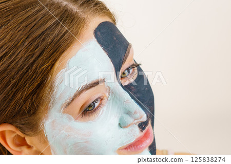 Girl with black white mud mask on face 125838274