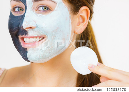 Girl remove black white mud mask from face Girl remove black white mud mask from face 125838278