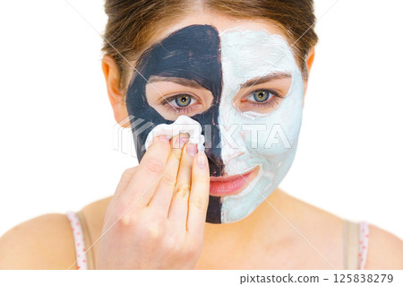Girl remove black white mud mask from face 125838279