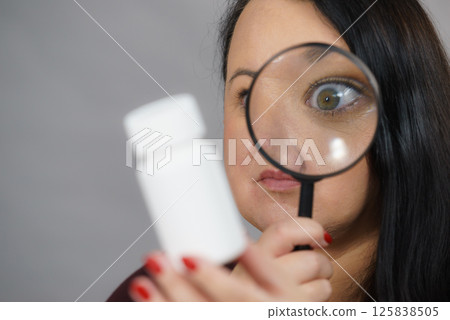 Woman investigating ingredients of medicines 125838505