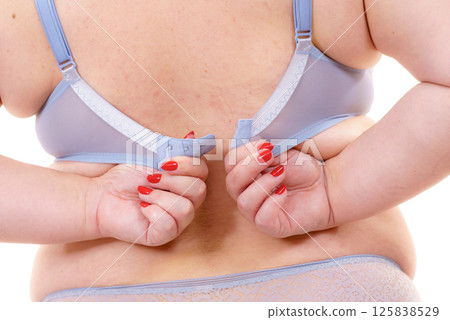 Woman back view putting on her bra lingerie. Woman back view putting on her bra lingerie. 125838529