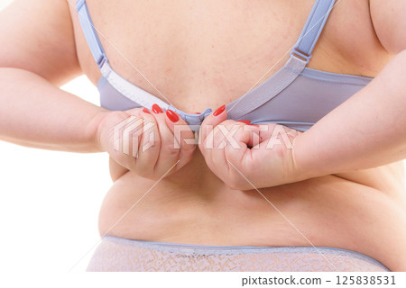 Woman back view putting on her bra lingerie. Woman back view putting on her bra lingerie. 125838531