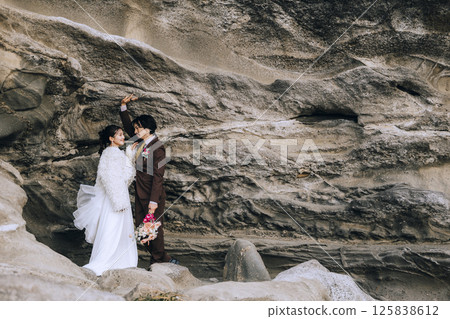 A young couple taking pre-wedding photos at Jogashima 125838612