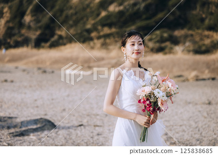 A young couple taking pre-wedding photos at Jogashima 125838685