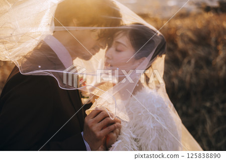 A young couple taking pre-wedding photos at Jogashima 125838890