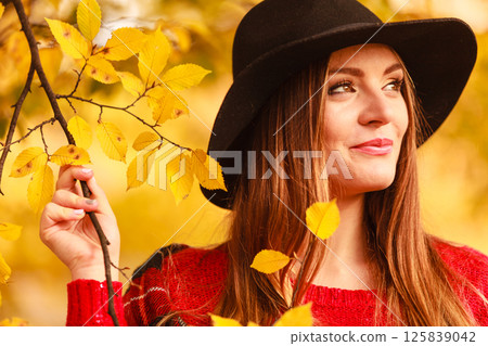 Charming woman walking in autumnal park Charming woman walking in autumnal park 125839042