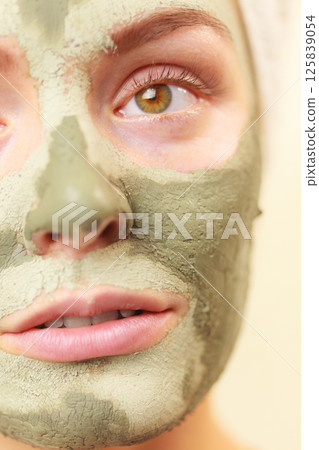 Woman face with green clay mud mask 125839054