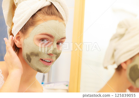 Woman face with green clay mud mask 125839055