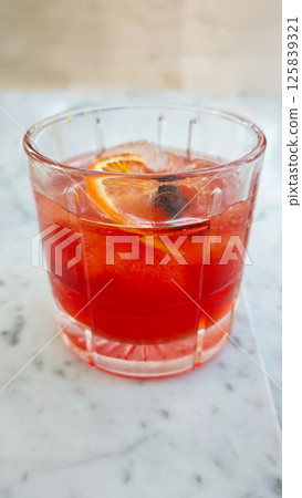 Refreshing Ice Hibiscus Tea in a Glass with Orange Slice on Marble Background in a Cafe 125839321