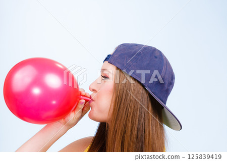 Teen girl blowing red balloon. Teen girl blowing red balloon. 125839419