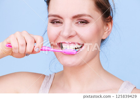 Woman brushing cleaning teeth 125839429