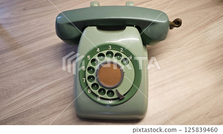 Vintage Green Rotary Dial Telephone or phone on Wooden Surface in Classic Design Vintage Green Rotary Dial Telephone or phone on Wooden Surface in Classic Design 125839460