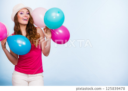 Woman playing with many colorful balloons 125839478