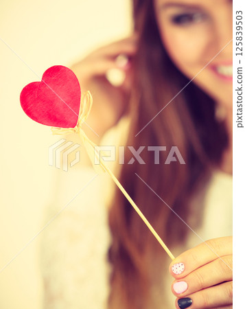 Beautiful woman holding heart shaped hand stick Beautiful woman holding heart shaped hand stick 125839503