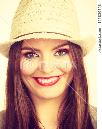 Happy flirty woman wearing sun hat Happy flirty woman wearing sun hat 125839598